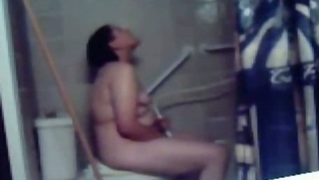 Chubby amateur dark haired nympho masturbates on the toilet bowl